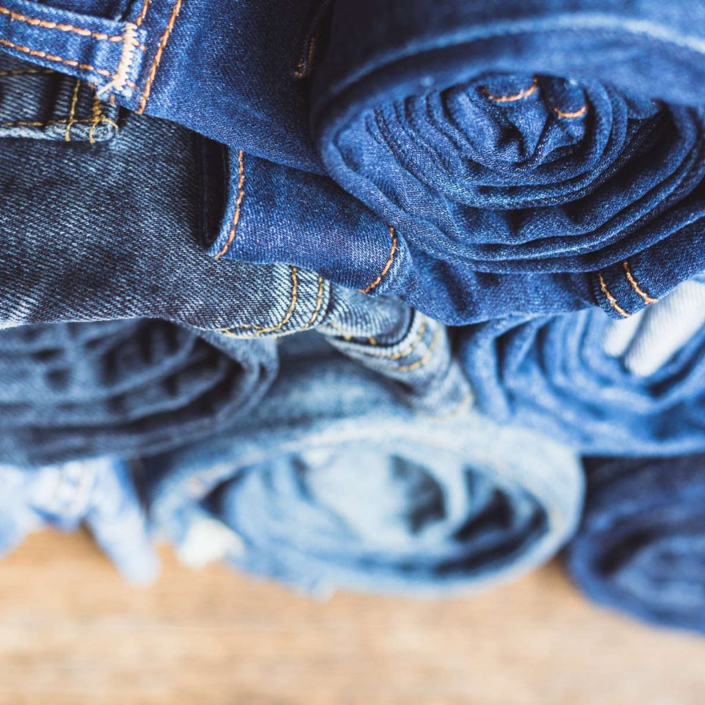 Jeans stacked on a wooden background